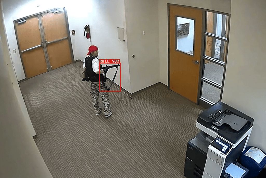 AI gun detection with bounding boxes on a simulated school security camera feed