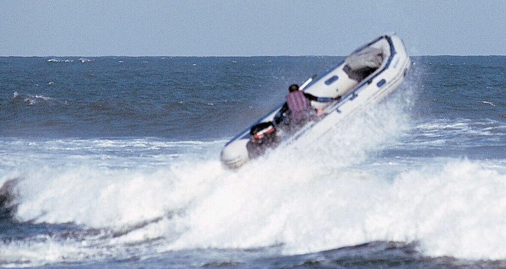 Small power boat jumping over waves